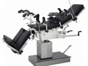 Surgical operating table with multiple adjustable sections and supports on a pedestal base in a hospital setting.