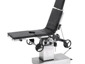 Adjustable surgical table with padded sections, wheels, and a motorized base in a hospital setting.